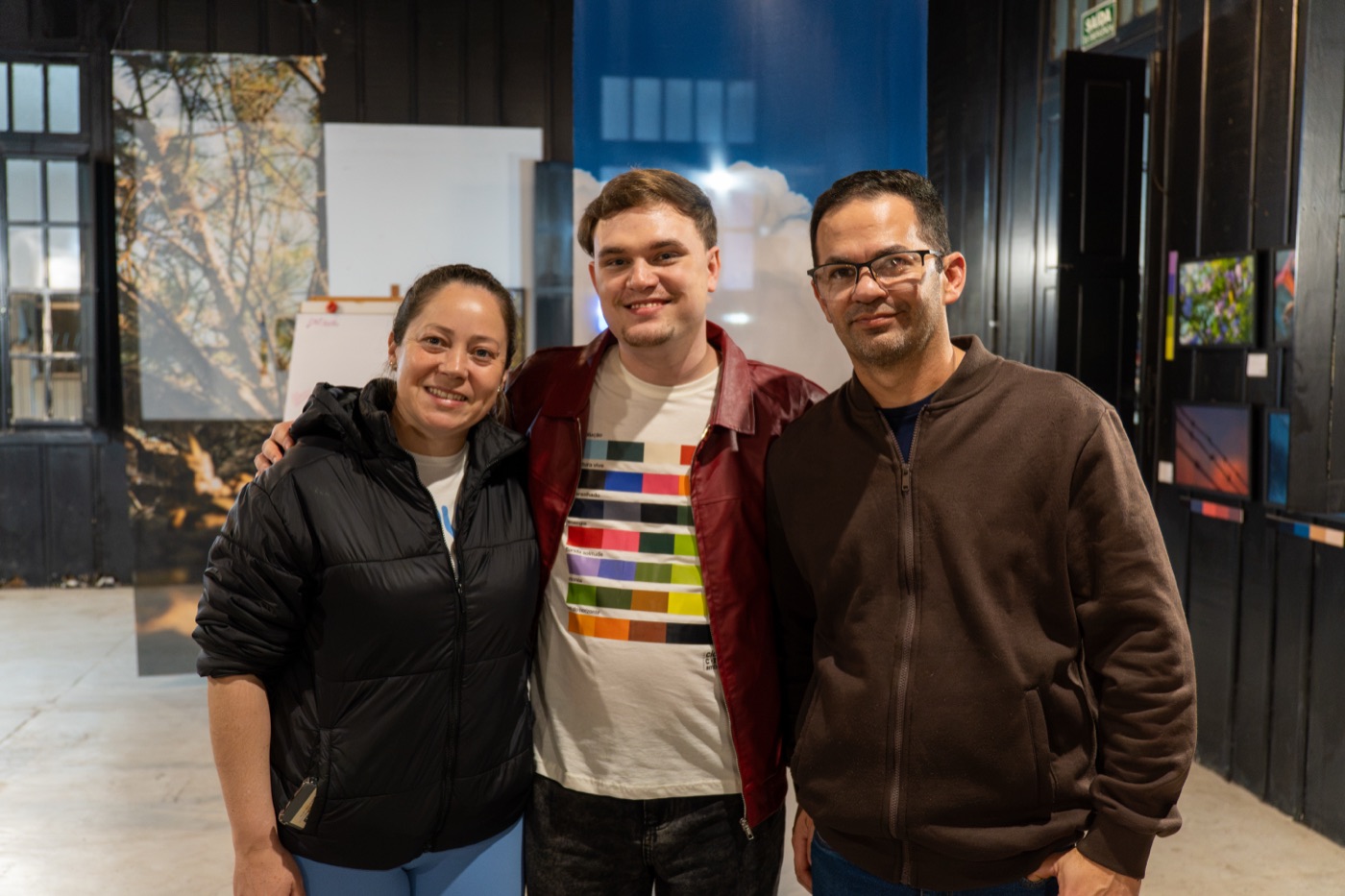 Anthony Buqui posa com visitantes durante a abertura da exposição Cidade, Cor e Ambiente na Galeria Estação da Arte, em Passo Fundo.