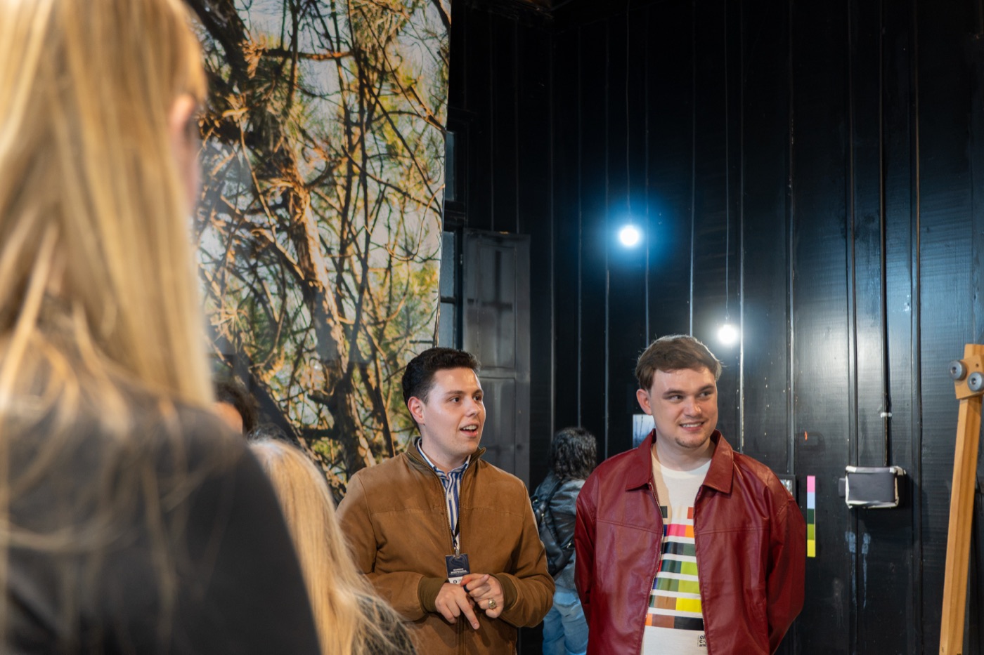 Anthony Buqui conversa com um visitante em frente a uma peça em voil da exposição Cidade, Cor e Ambiente na Galeria Estação da Arte, em Passo Fundo.